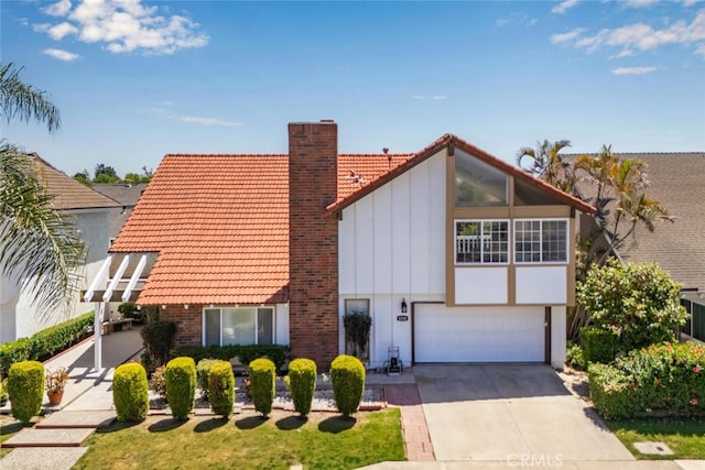 4200 Avenida Sevilla, Cypress, CA 90630 - view of front of home featuring a tiled roof, a chimney, a garage, driveway, and board and batten siding