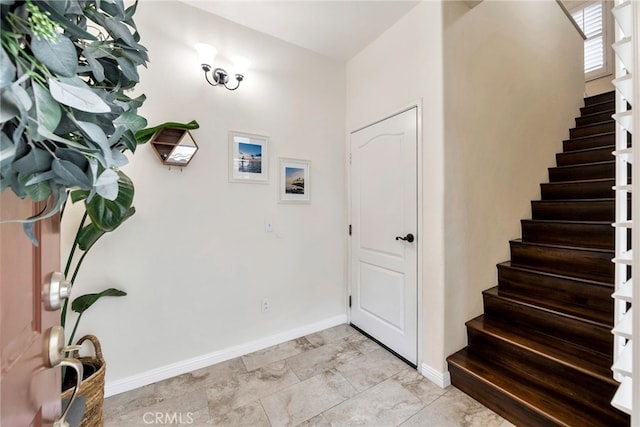 entrance foyer with baseboards and stairway
