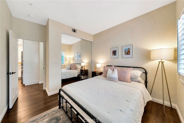bedroom featuring baseboards, wood finished floors, and visible vents