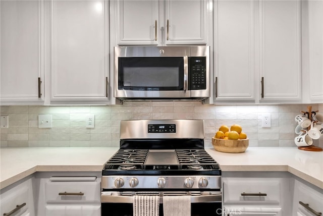kitchen with light countertops, white cabinetry, appliances with stainless steel finishes, and decorative backsplash