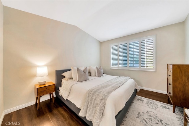 bedroom featuring baseboards, dark wood-style floors, and lofted ceiling