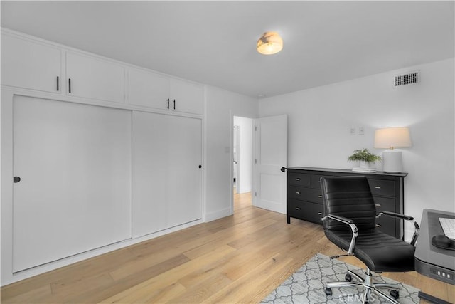 bedroom featuring light wood finished floors, a closet, and visible vents