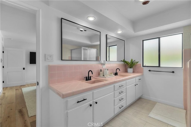 full bath with double vanity, a sink, and decorative backsplash
