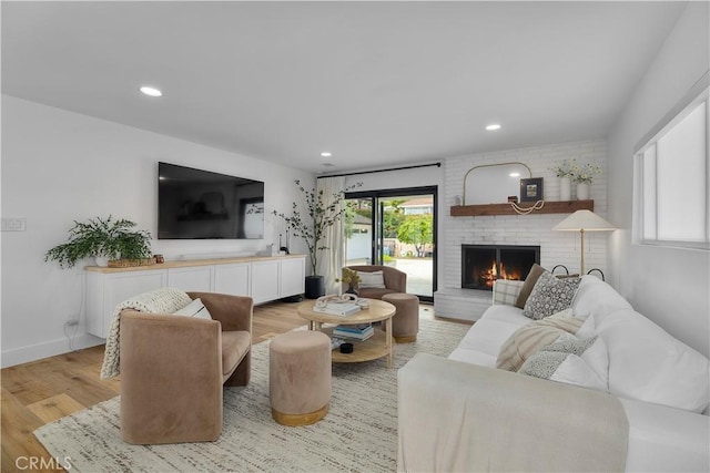 living area with light wood-type flooring, recessed lighting, baseboards, and a fireplace