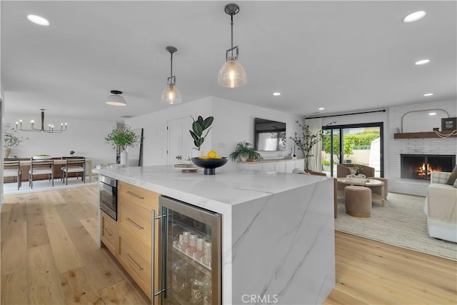 kitchen featuring light wood-style floors, modern cabinets, open floor plan, and wine cooler