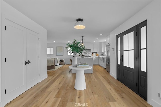 entryway with light wood-style floors and recessed lighting