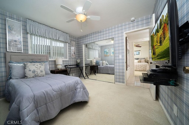 bedroom with wallpapered walls, a ceiling fan, and carpet flooring