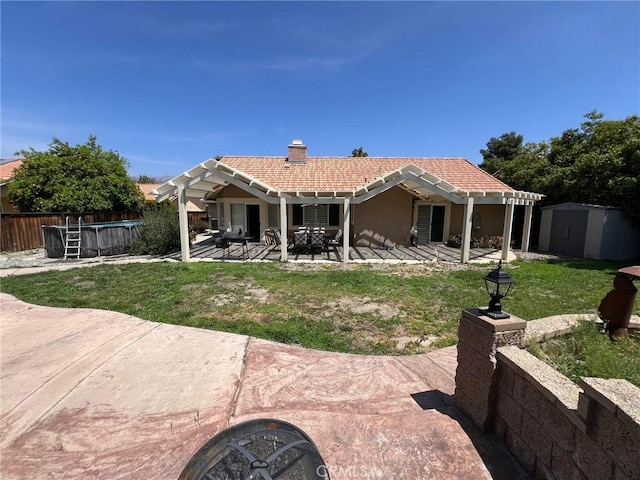 back of property featuring a storage unit, a pergola, a patio, an outdoor structure, and a tiled roof