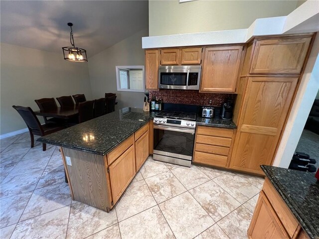 kitchen featuring decorative backsplash, a peninsula, dark stone countertops, appliances with stainless steel finishes, and vaulted ceiling