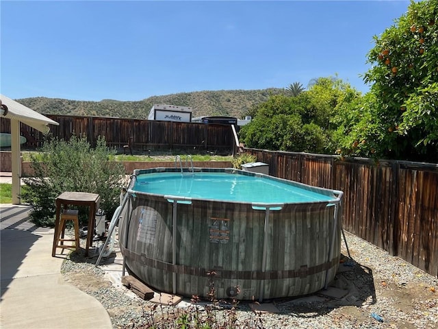 view of pool featuring a fenced in pool, a mountain view, and a fenced backyard