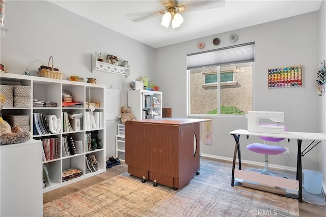 office area featuring baseboards, a ceiling fan, and wood finished floors