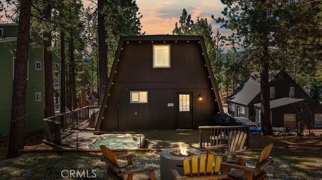 back of property with an outdoor fire pit