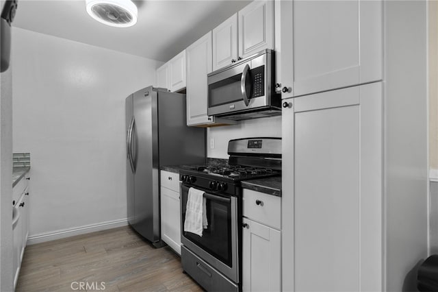 8990 19th St Unit 433, Rancho Cucamonga, CA 91701 - kitchen featuring dark countertops, baseboards, white cabinetry, light wood finished floors, and stainless steel appliances