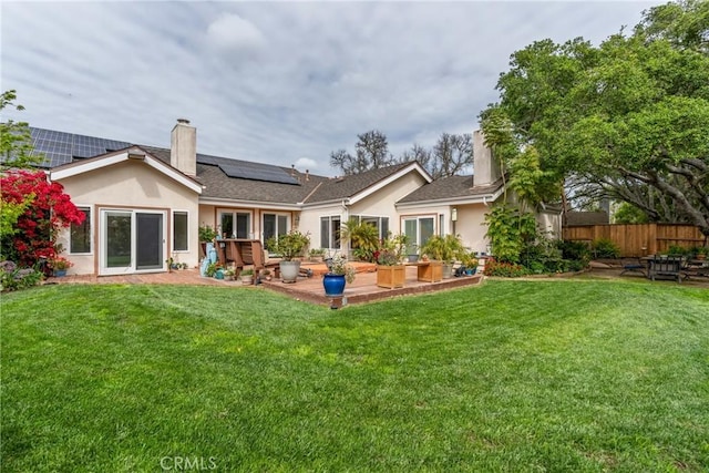 832 Onstott Rd, Lompoc, CA 93436 - rear view of property featuring a lawn, solar panels, stucco siding, and a chimney
