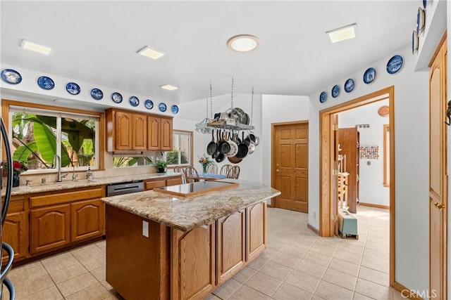 832 Onstott Rd, Lompoc, CA 93436 - kitchen with brown cabinetry, light tile patterned floors, a kitchen island, a sink, and stovetop