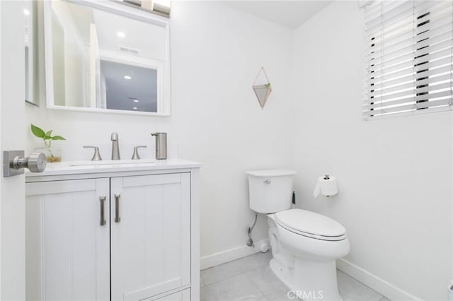 half bathroom with baseboards, tile patterned flooring, toilet, and vanity