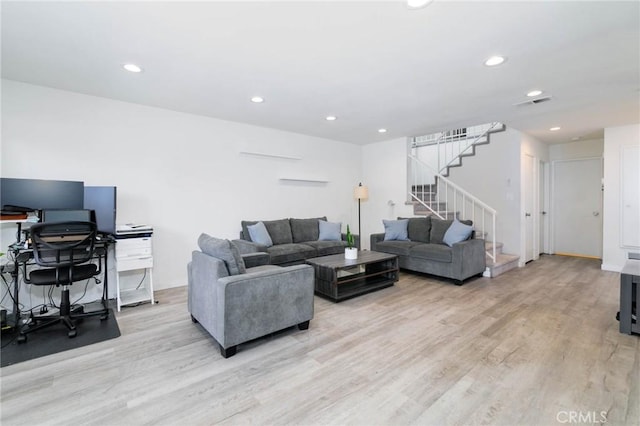 living room featuring recessed lighting, visible vents, light wood finished floors, and stairs