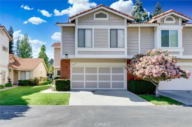 view of front of home with an attached garage, a front yard, driveway, and a tile roof