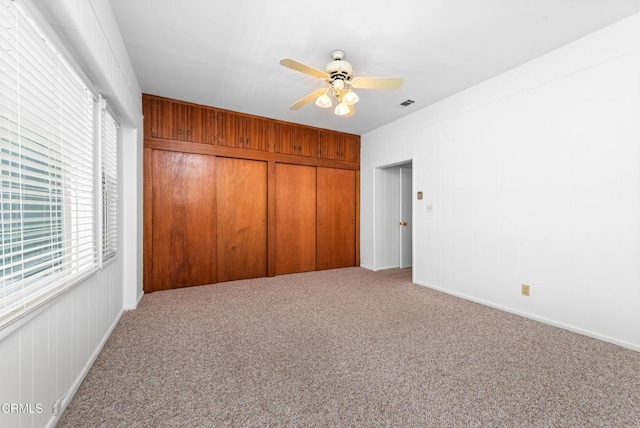 unfurnished bedroom with a closet, multiple windows, carpet floors, and visible vents