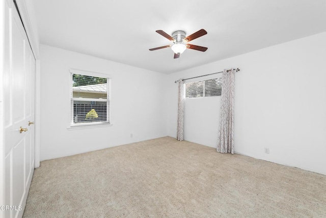 carpeted spare room featuring a ceiling fan