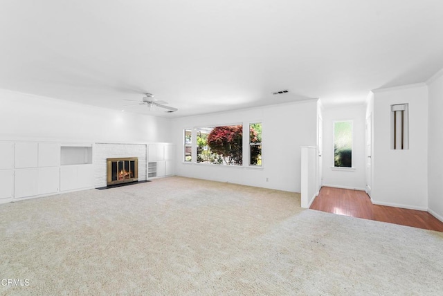 unfurnished living room featuring a fireplace, carpet, plenty of natural light, and a ceiling fan