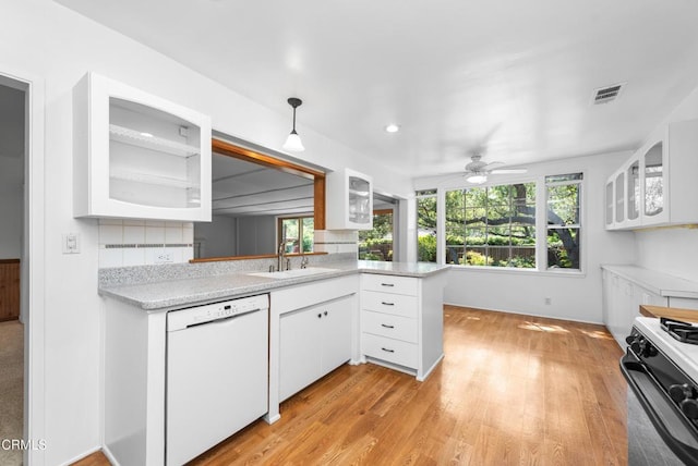 kitchen with light countertops, dishwasher, a sink, black range with gas stovetop, and visible vents