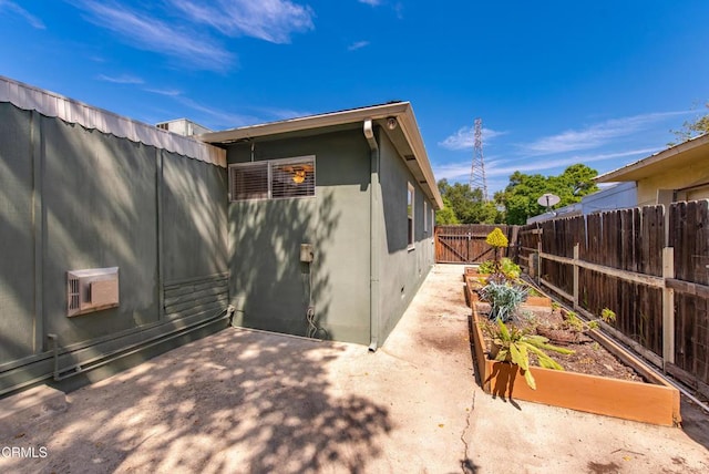 back of property featuring stucco siding, a garden, a patio, and a fenced backyard