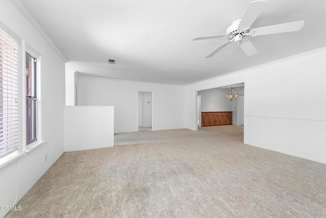 unfurnished living room with plenty of natural light, carpet flooring, and ceiling fan with notable chandelier