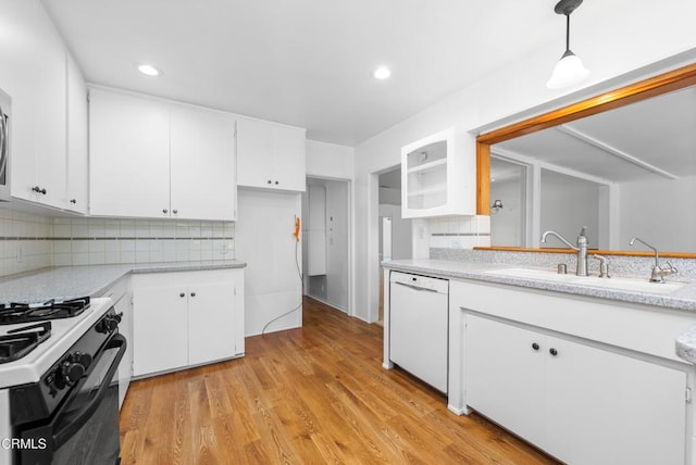 kitchen with light countertops, dishwasher, a sink, white cabinetry, and range with gas stovetop