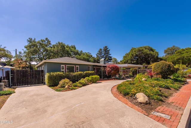 ranch-style home featuring fence and concrete driveway