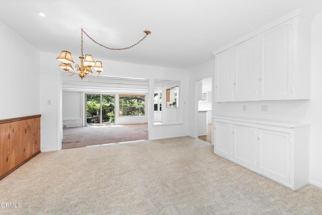 interior space featuring an inviting chandelier and light colored carpet