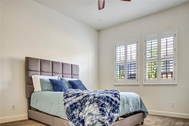 carpeted bedroom featuring a ceiling fan, multiple windows, and baseboards