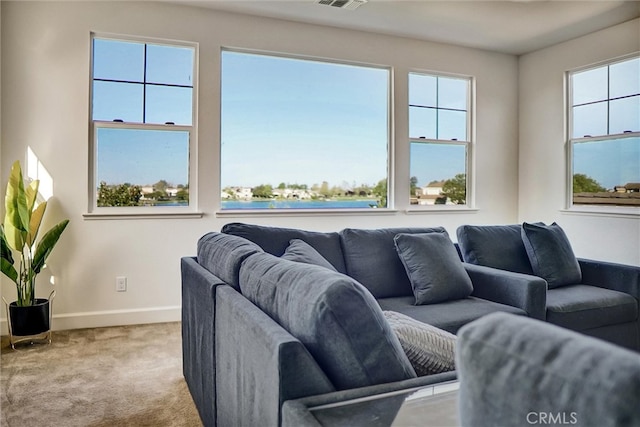 carpeted living area with baseboards and visible vents