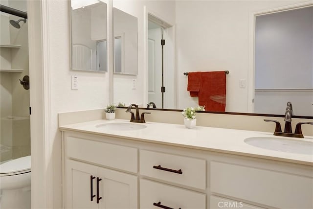 full bath featuring a shower, toilet, double vanity, and a sink