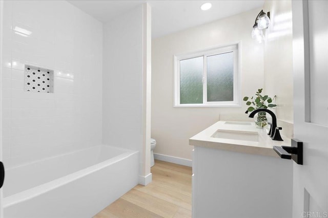 full bath with toilet, wood finished floors, baseboards, vanity, and recessed lighting