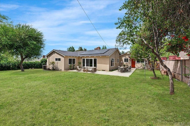 back of house with solar panels, stucco siding, a patio, outdoor lounge area, and cooling unit