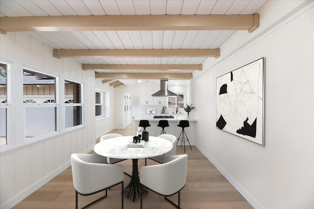 dining area with light wood finished floors, baseboards, and wood ceiling