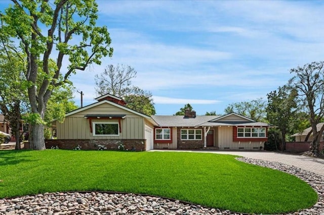 single story home with driveway, board and batten siding, a front lawn, and an attached garage