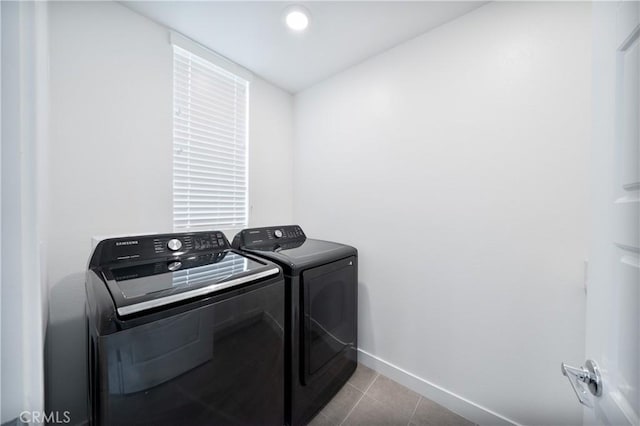washroom with tile patterned floors, washing machine and dryer, laundry area, and baseboards