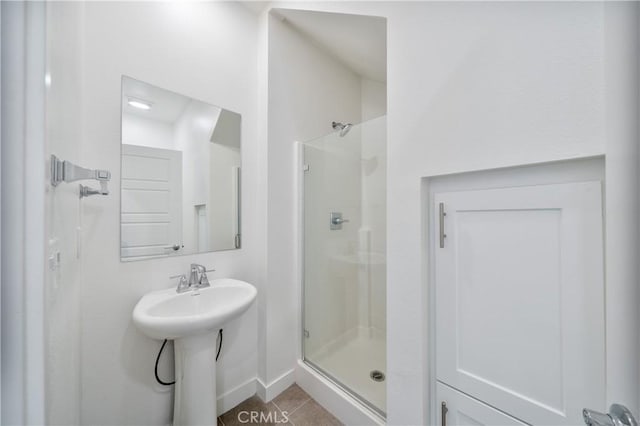 full bathroom with a shower stall, baseboards, tile patterned flooring, and a sink