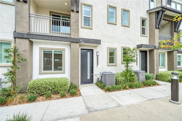 entrance to property with cooling unit and stucco siding