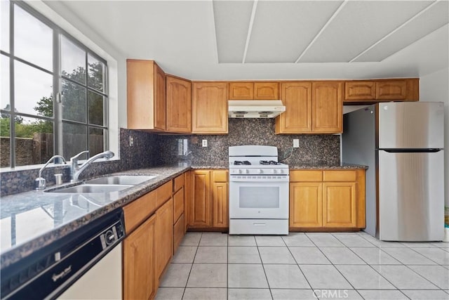 1029 S Reservoir St, Pomona, CA 91766 - kitchen featuring white appliances, under cabinet range hood, a sink, and dark stone counters