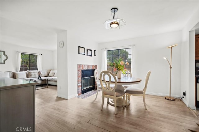 1029 S Reservoir St, Pomona, CA 91766 - dining space featuring baseboards, light wood finished floors, and a fireplace