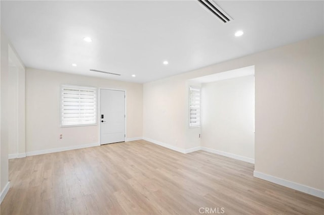 unfurnished room with visible vents, light wood-type flooring, recessed lighting, and baseboards
