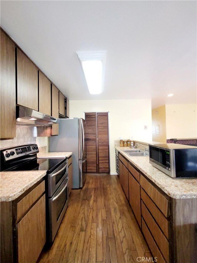17762 Palo Verde Ave, Cerritos, CA 90703 - kitchen featuring appliances with stainless steel finishes, under cabinet range hood, dark wood finished floors, and a peninsula