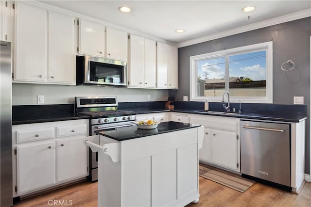 kitchen featuring white cabinetry, appliances with stainless steel finishes, a sink, and light wood-type flooring