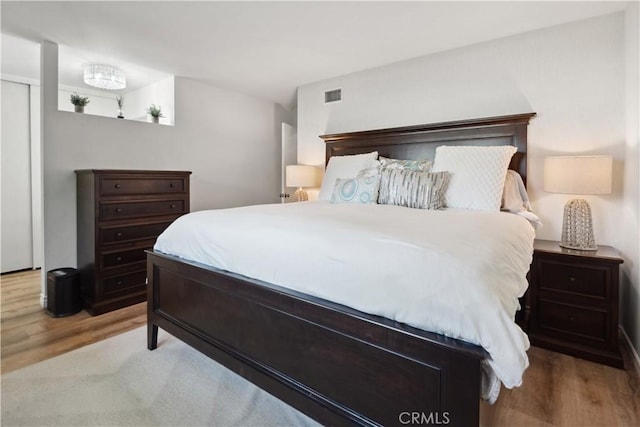 bedroom featuring visible vents and wood finished floors