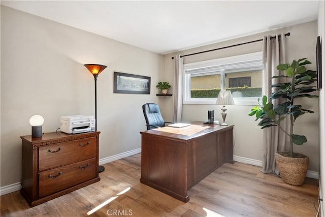 office space featuring baseboards and light wood-style flooring