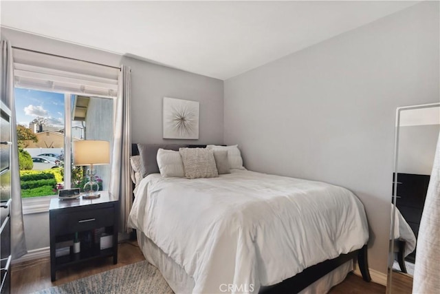 bedroom featuring baseboards and wood finished floors