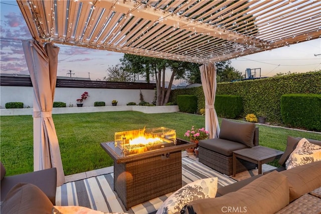 patio terrace at dusk featuring a lawn, a deck, a fenced backyard, an outdoor living space with a fire pit, and a pergola